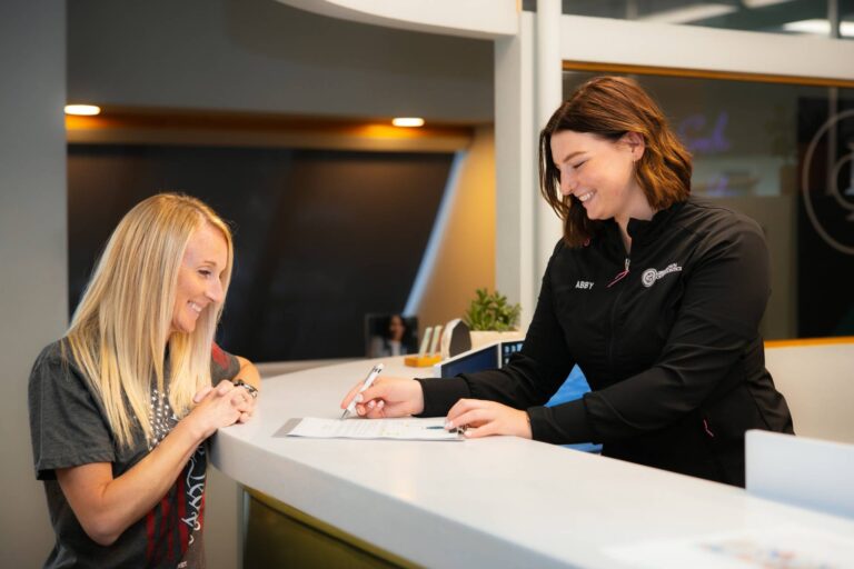 patient signing up her orthodontic journey with Greg Brown Orthodontics